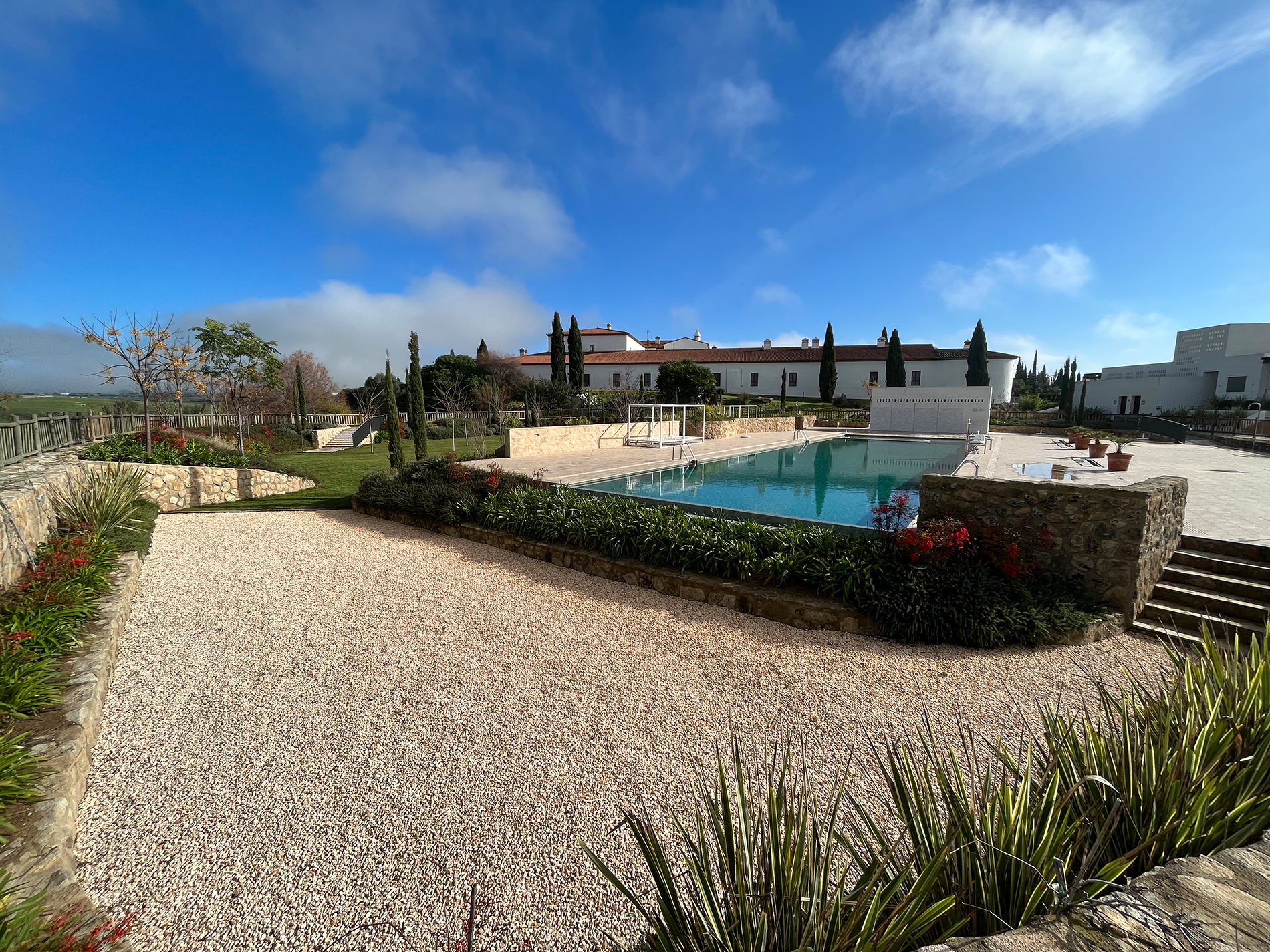 Jardín residencial en Toledo con piscina, piedra y vegetación